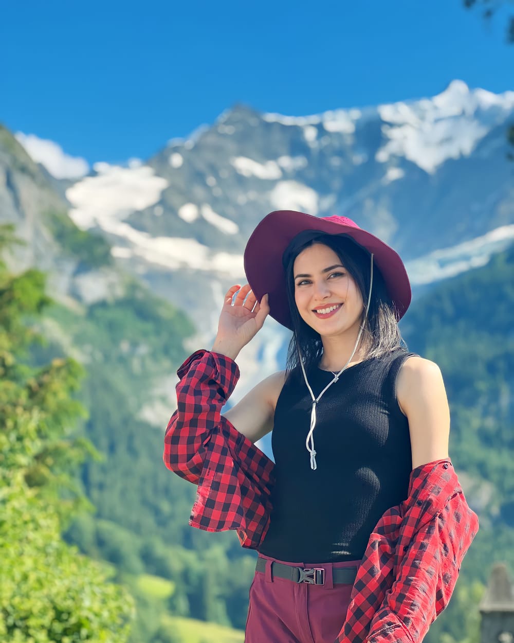 مهسا مهربان با کلاه قرمز جلوی کوه‌های برفی
